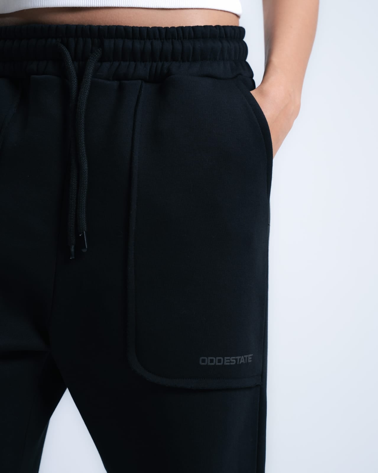 A black baggy sweatpants and white t-shirt with a light grey background