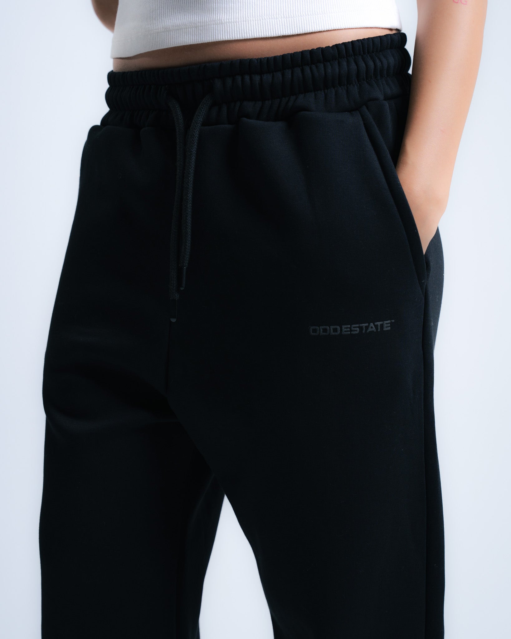 Black pants with 'Odd Estate' logo on a white background