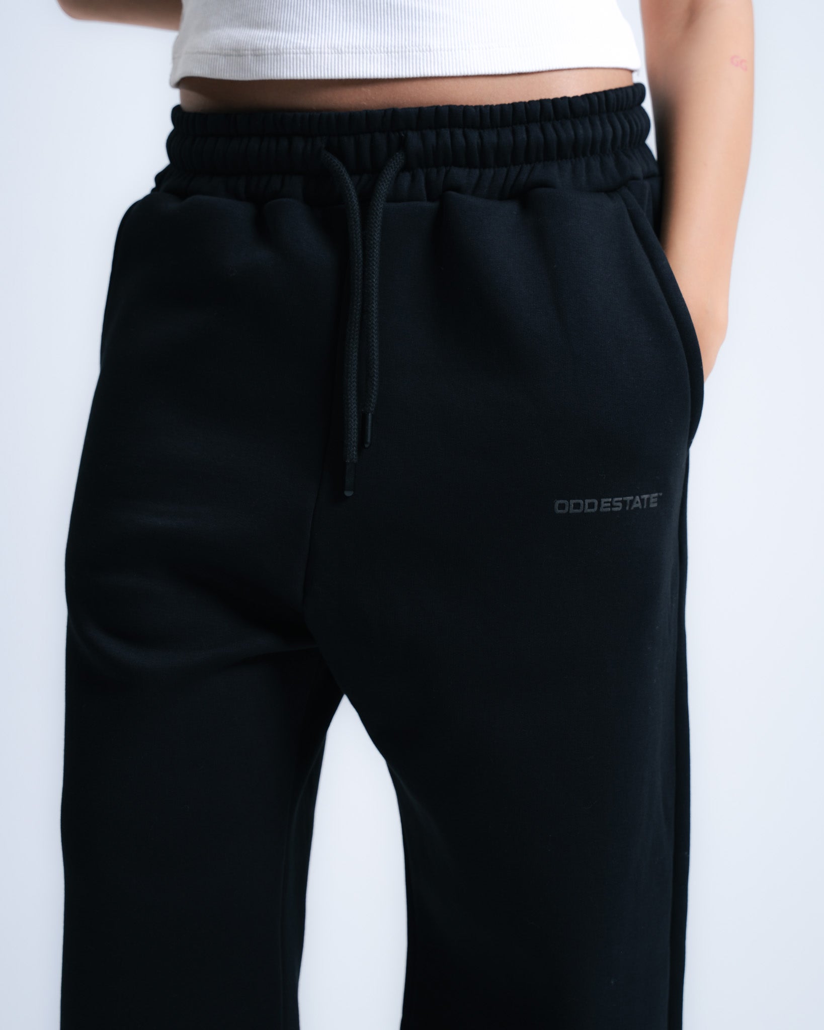 Black jogger pants with a brand logo on a white background