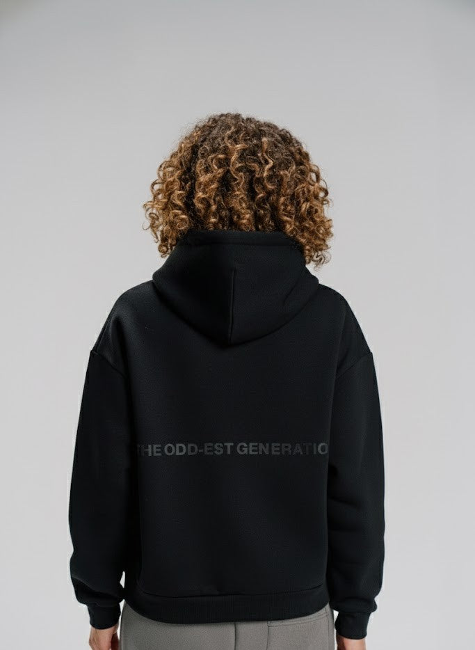 Person wearing a black hoodie with text on the back against a gray background