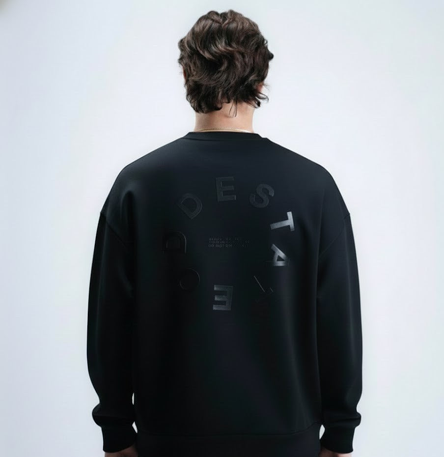 Person wearing a black sweatshirt with text on the back against a white background