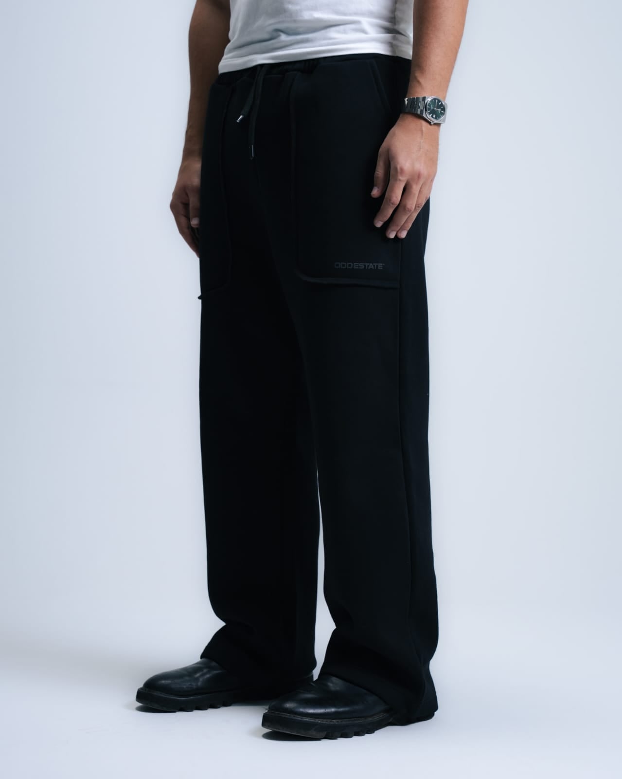Person wearing black cargo pants on a white background