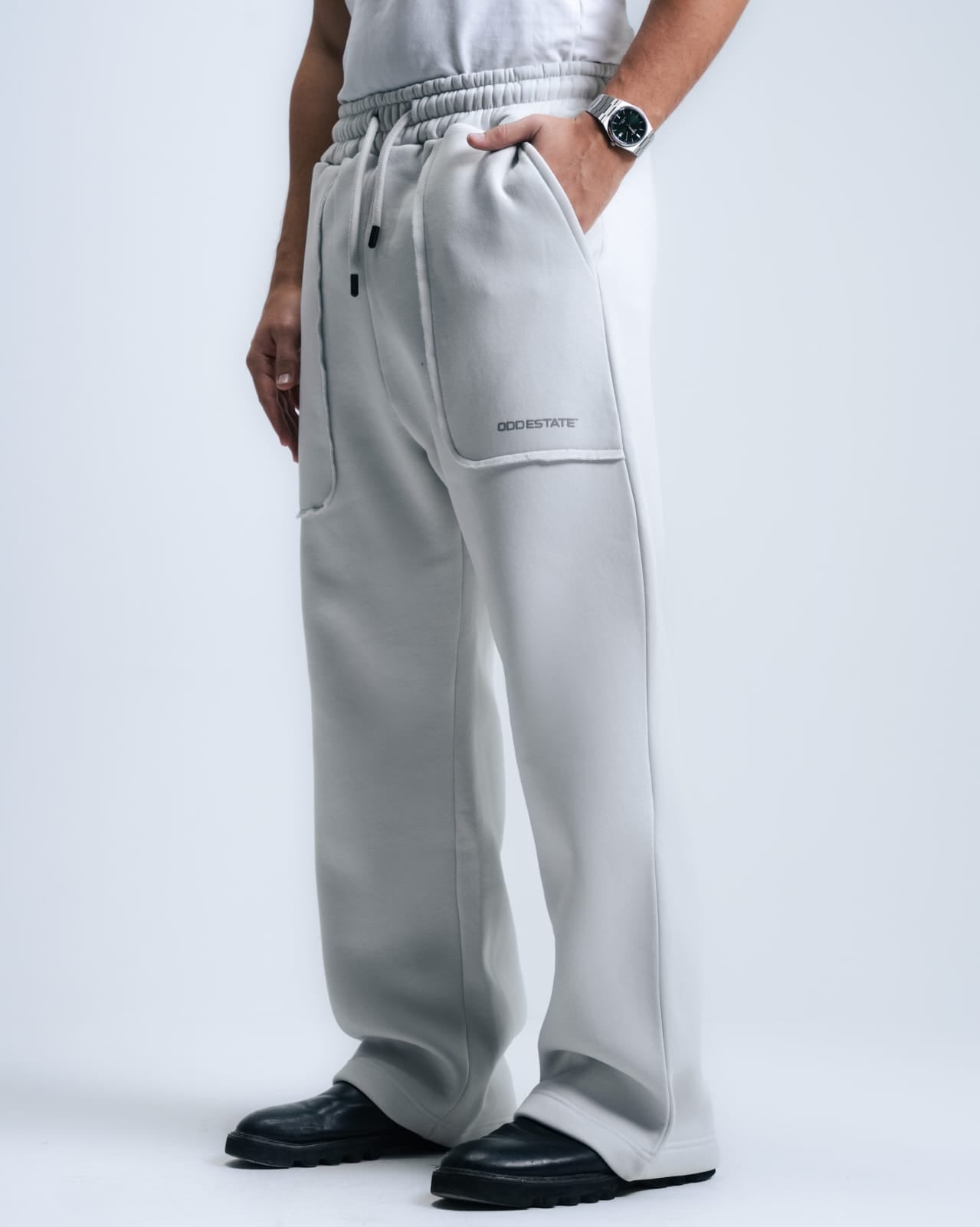 Person wearing gray sweatpants with a brand logo on a white background