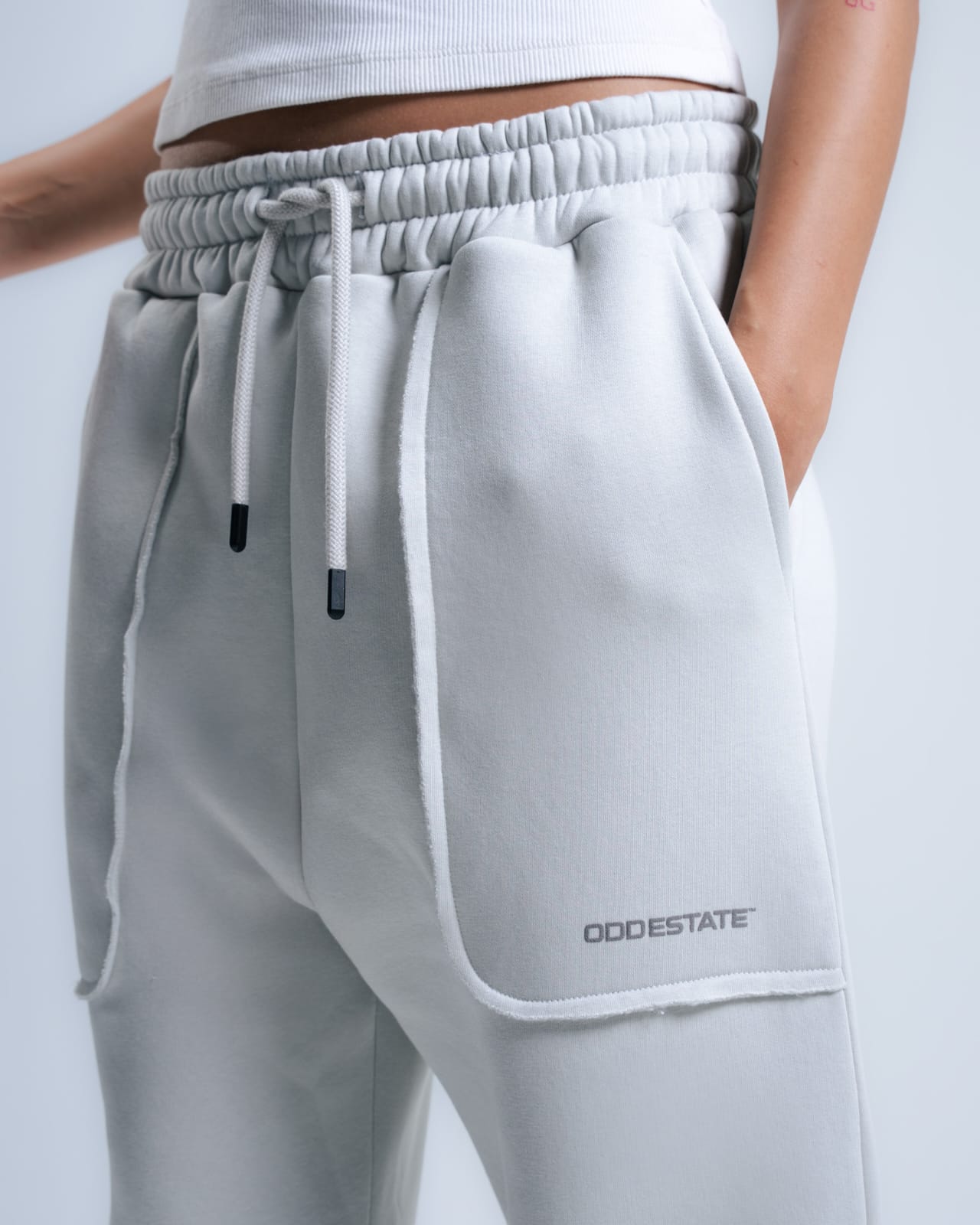 Gray sweatpants with a pocket and drawstring, featuring the brand 'ODDSTATE'.